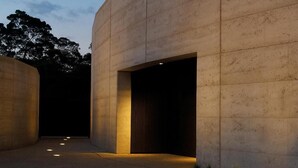 Un edificio moderno con fachada de hormigón y un amplio acceso abierto.