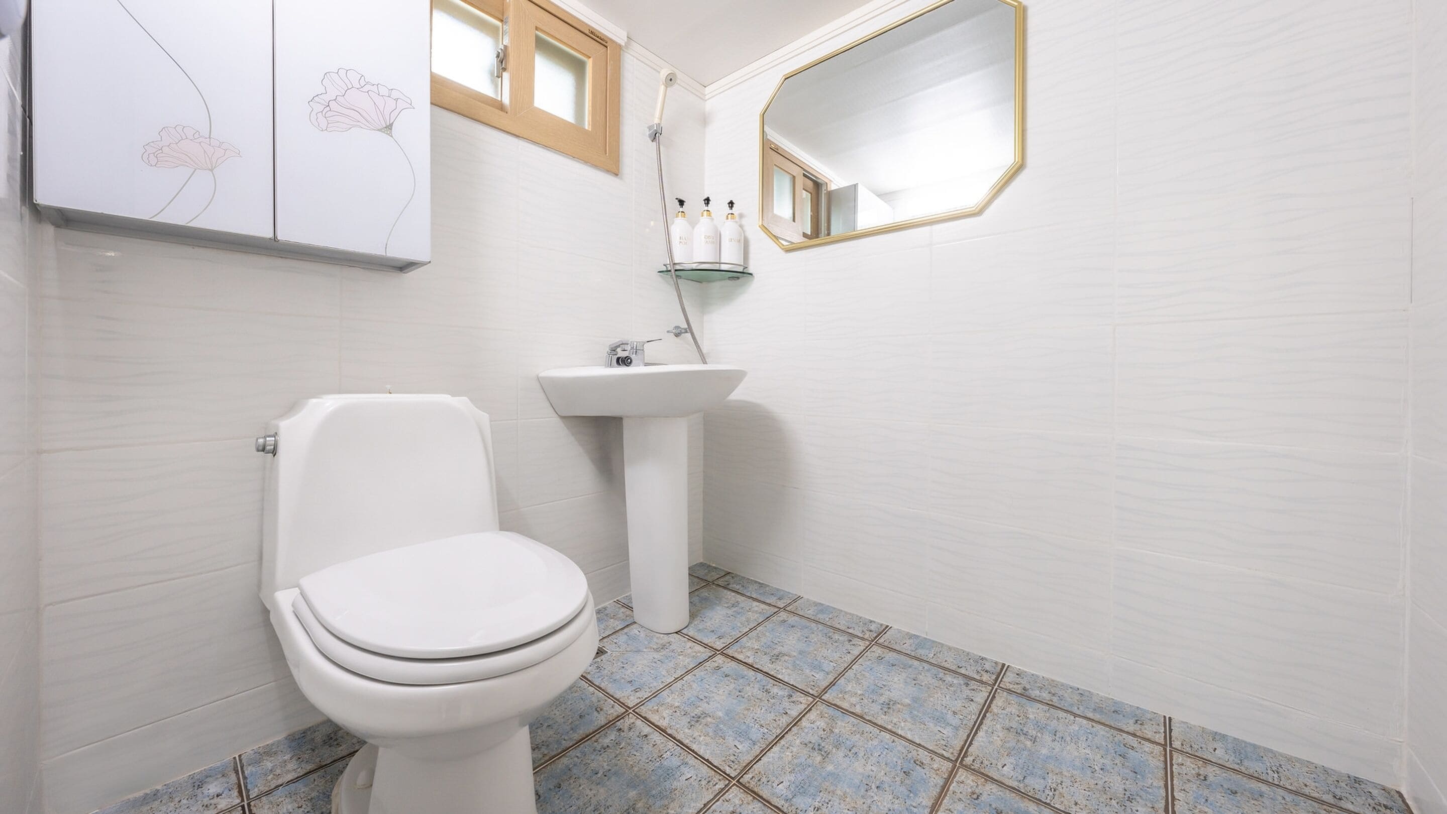 Une salle de bain avec des toilettes, un lavabo et un miroir.