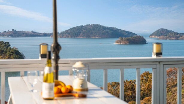 Un balcon donnant sur une mer calme et des îles lointaines.
