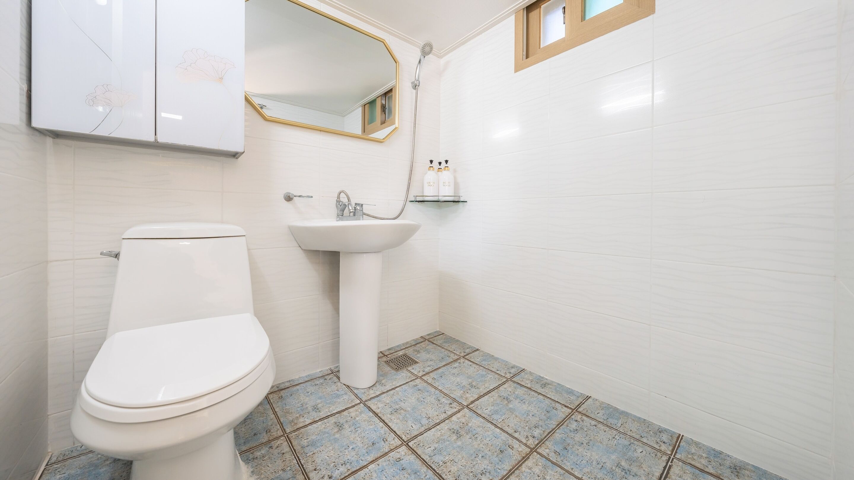 A bathroom with a toilet, sink, and shower.