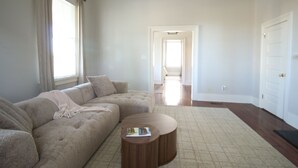 Ein Wohnzimmer mit einem Ecksofa, einem runden Couchtisch und einem Teppich.