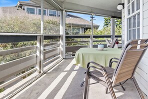 A covered patio with a table and chairs, a view of a house, and a 'Welcome' sign. - 273 Sea Woods Veranda 3BD - Keep Palm & Carry On (New Smyrna Beach)