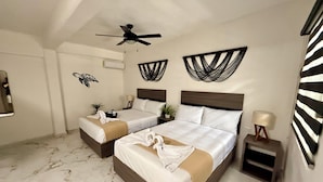 A hotel room with two beds, a ceiling fan, wall art, a small table with a lamp, and a marble floor. - Coco Azul Hotel Boutique (Playa del Carmen)