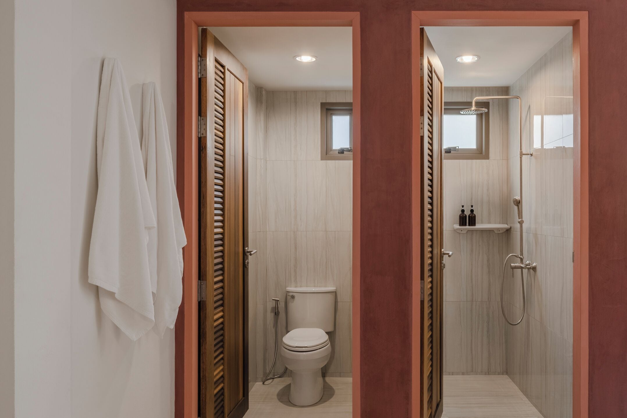A modern bathroom with a toilet, shower, and a towel rack.