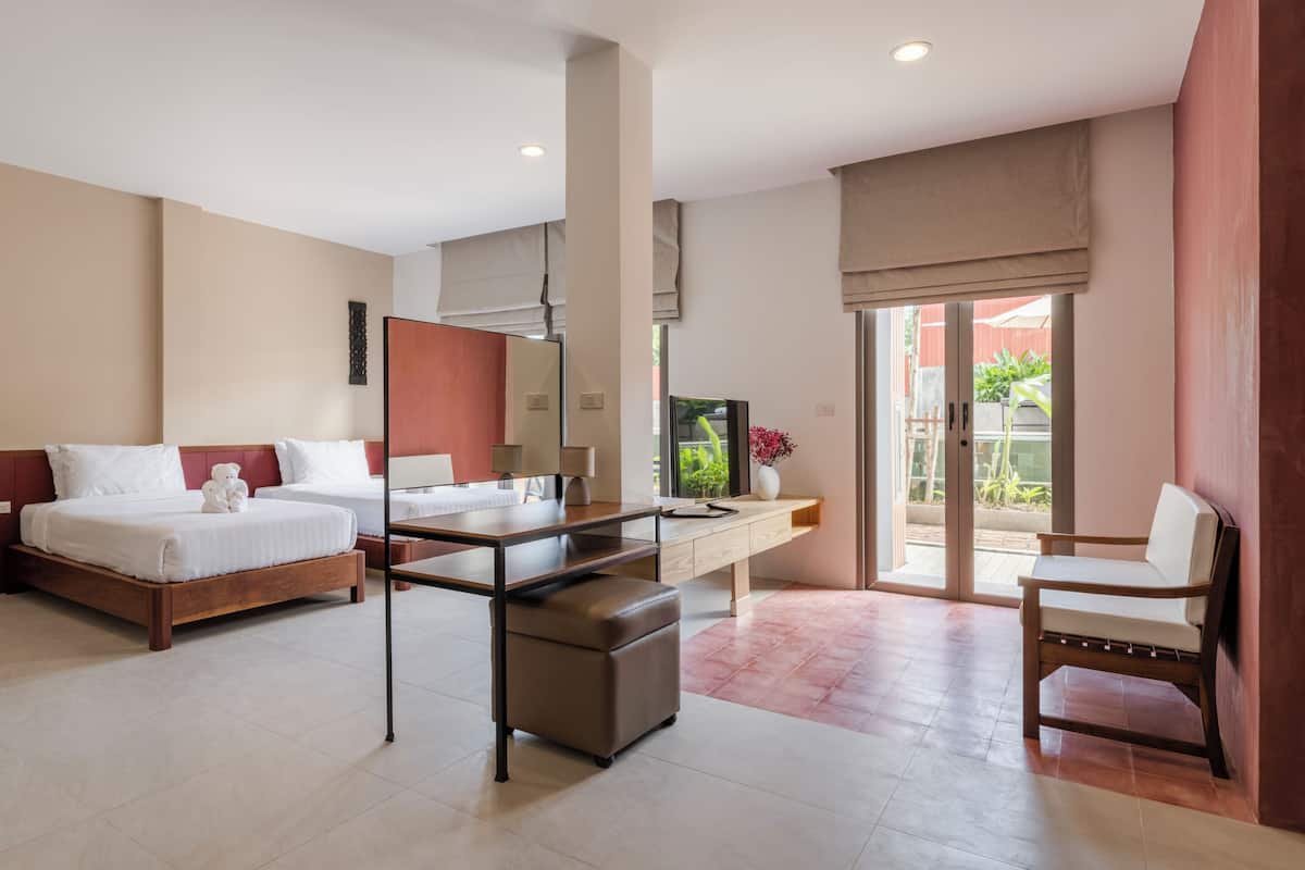 A hotel room with a bed, desk, chair, and a view of the outdoors.