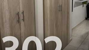Habitación moderna con armarios de madera, un televisor de pantalla plana y el número '302' a la vista.