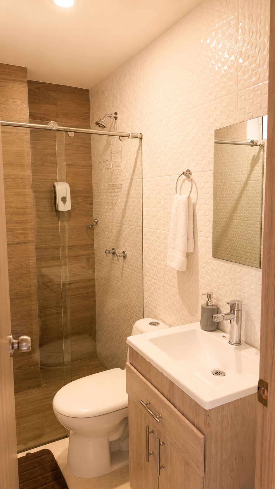 A modern bathroom with a glass-enclosed shower, a white toilet, and a vanity with a mirror.