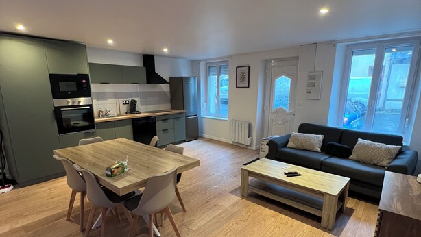 Un appartement moderne comprenant un coin repas, une cuisine et un salon.