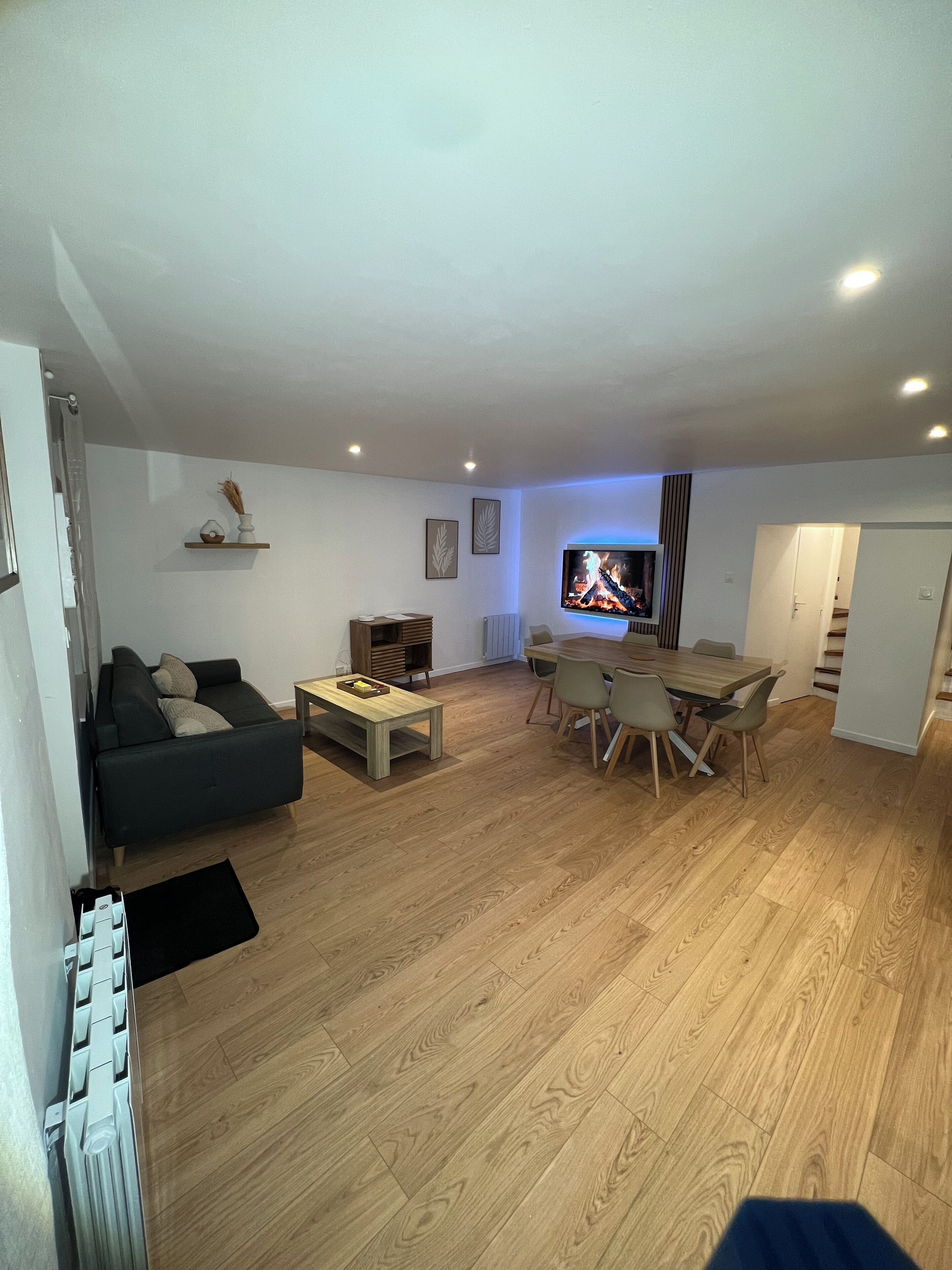 A living room with a sofa, coffee table, TV, and dining area.