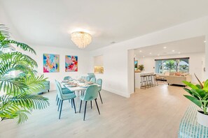 Ein modernes Interieur mit Essbereich, Küche und Wohnbereich.