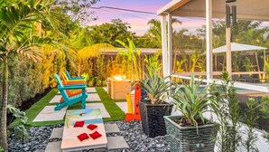 Une terrasse avec un foyer, des chaises colorées et des plantes en pot.