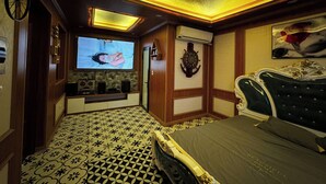 A room with a bed, a television, a clock, and a wall-mounted shelf. - Homestay nha go Lan Anh (Tu Vu)
