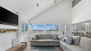 A spacious living room with a large TV, a sofa, and a coffee table.