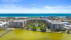 Un hôtel de grande hauteur doté de nombreux balcons, d’une piscine centrale et offrant une vue sur la plage et l’océan.