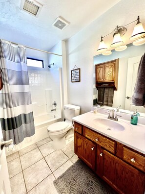 A bathroom with a shower, toilet, sink, and wooden vanity. - Spacious Prescott Home w/Fenced Yard & Central Loc (Prescott)
