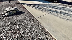 A residential garage with a clear driveway leading to it, surrounded by a gravel area and a tree. - Spacious Prescott Home w/Fenced Yard & Central Loc (Prescott)