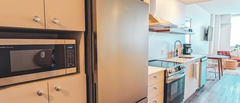 A modern kitchen with a built-in microwave, oven, and refrigerator.