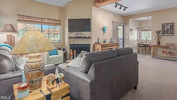 A living room with a sofa, a coffee table, a lamp, and a ceiling fan. - Cozy and convenient Condo (Mesa)