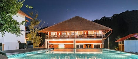 Un edificio de dos pisos con piscina delantera.