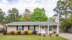 A single-story house with a front porch, a garage, and a small front yard with shrubs. - 10 Min. Drive From Tournament! WiFi, Parking for 3! Fire Pit! TV's In All Rooms! (Martinez)