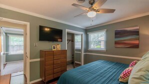 A bedroom with a bed, dresser, TV, and windows. - 10 Min. Drive From Tournament! WiFi, Parking for 3! Fire Pit! TV's In All Rooms! (Martinez)