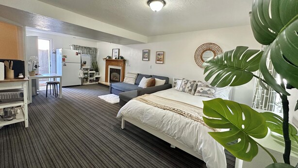 Un dormitorio moderno con cama, escritorio y kitchenette.