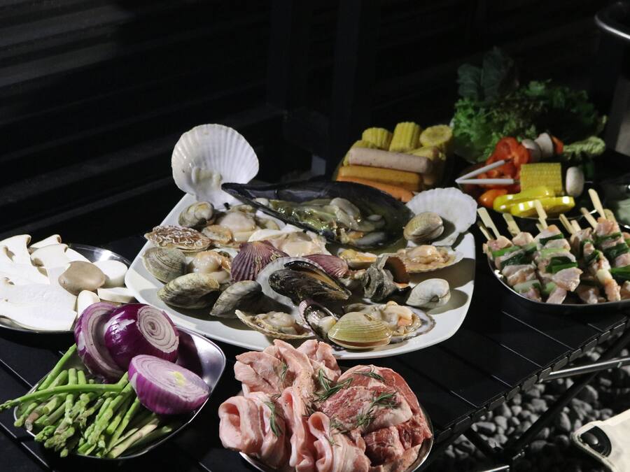 Una variedad de mariscos y verduras sobre una mesa.