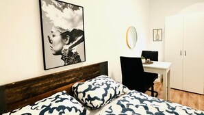 A bedroom with a bed, a desk, and a wardrobe. - Modern Room Two, Ideally Located Near Atzgersdorf (Vienna)