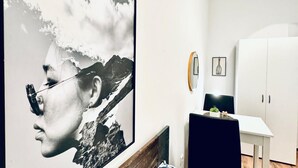 A room with a large framed artwork, a white cabinet, and a small table with a plant. - Modern Room Two, Ideally Located Near Atzgersdorf (Vienna)