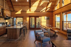 Een ruime hut met een grote keuken, een eethoek en een balkon met uitzicht.