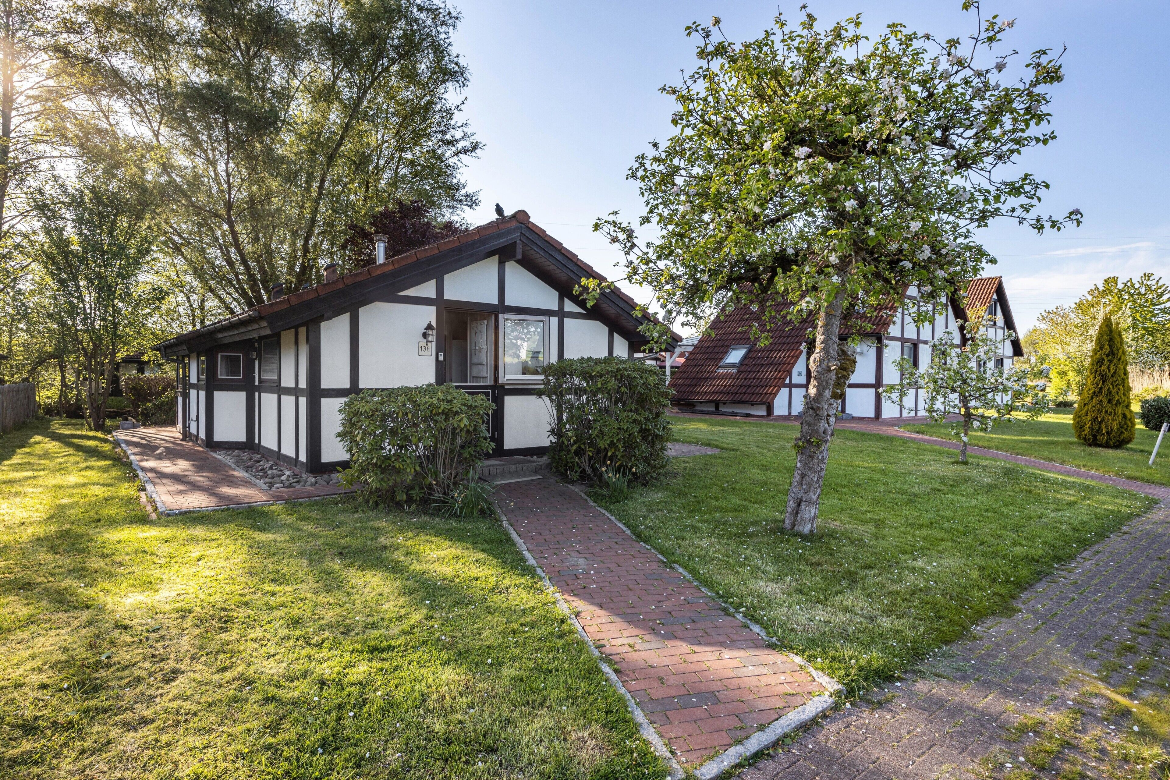 A traditional half-timbered house with a brick pathway leading to the entrance.