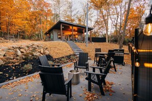 Une cabane dotée d’un patio couvert, de meubles d’extérieur et d’un barbecue.