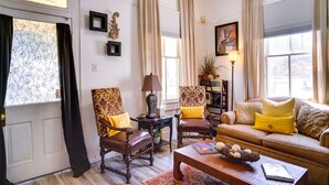 A living room with a sofa, two armchairs, a coffee table, and a lamp. - Charming 2-bedroom house with WiFi, AC in enchanting downtown Opelousas. (Opelousas)