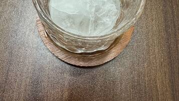 Un tazón de vidrio transparente con hielo sobre una superficie de madera.