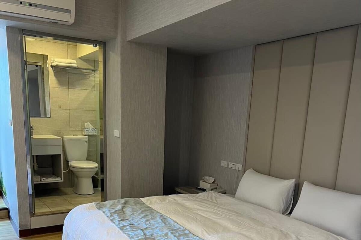 Een moderne slaapkamer met een groot bed, een nachtkastje en een inbouwkleerkast.