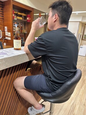 A person seated at a bar with a bottle of The Balvenie DoubleWood whisky. - Liou Lian Ke Zhan HOTEL (Luodong)