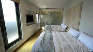 Una habitación de hotel moderna con una cama grande, televisión, ducha y vistas a la ciudad.