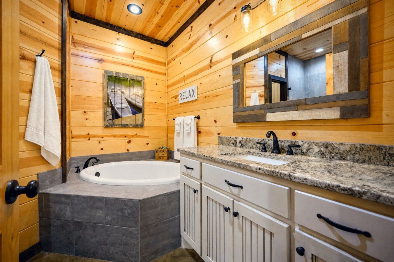 A wooden cabin-style bathroom with a freestanding bathtub, a sink, and a mirror above the vanity.