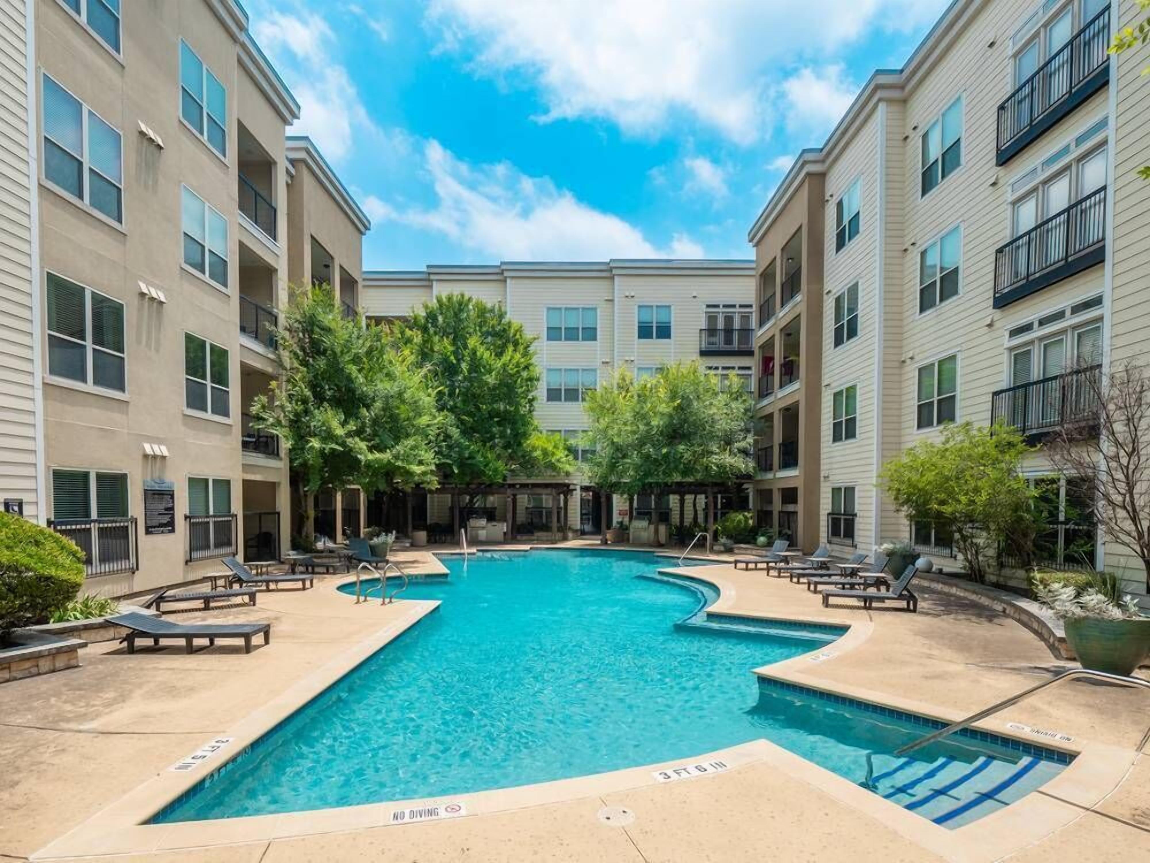 A pool area with lounge chairs and a no diving sign.