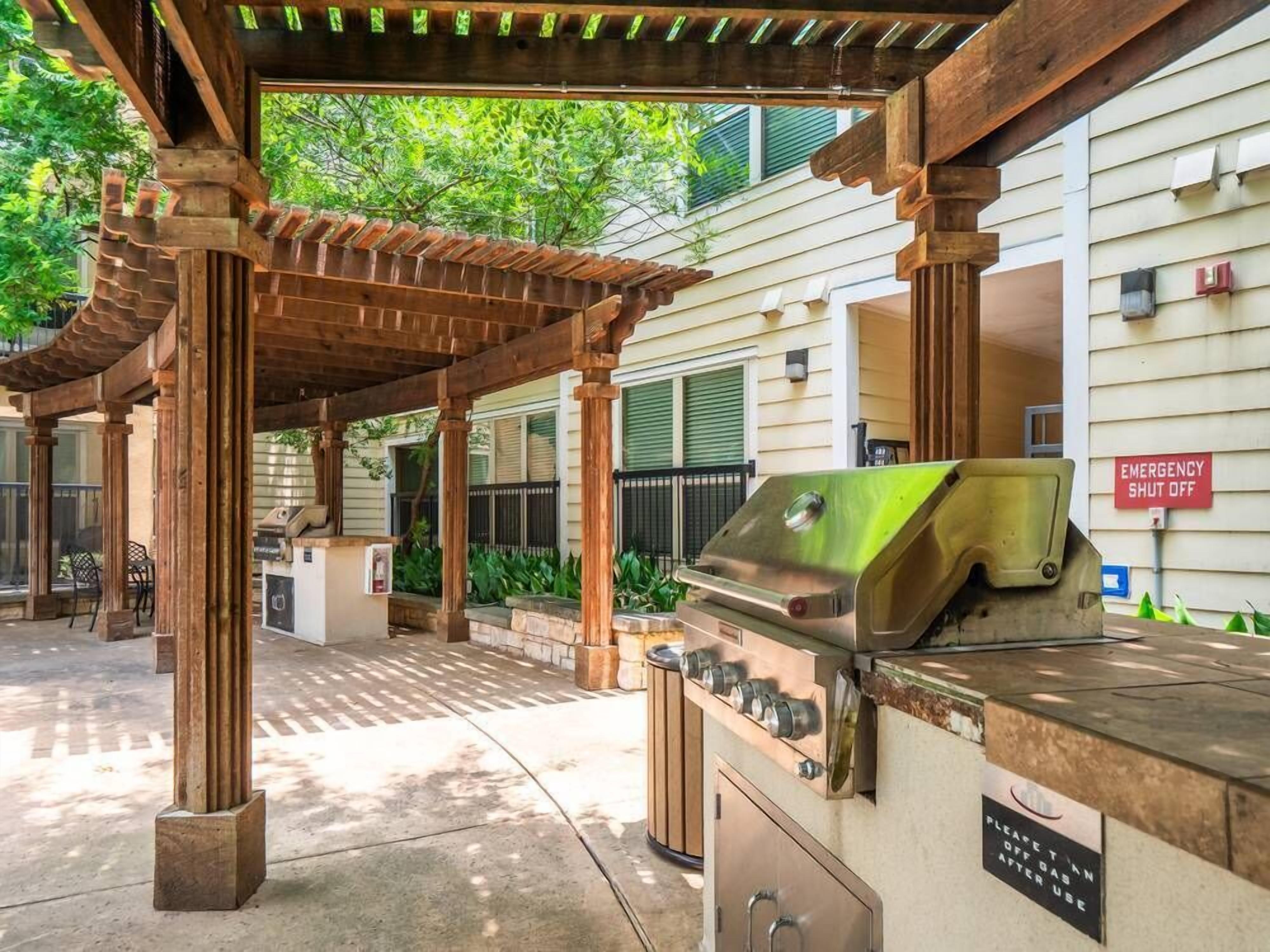 An outdoor barbecue area with a grill and a covered seating area.