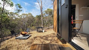 An outdoor patio with a fire pit, seating, and a view of the forest. - Eucalypt Escape by Tiny Away (Coimadai)
