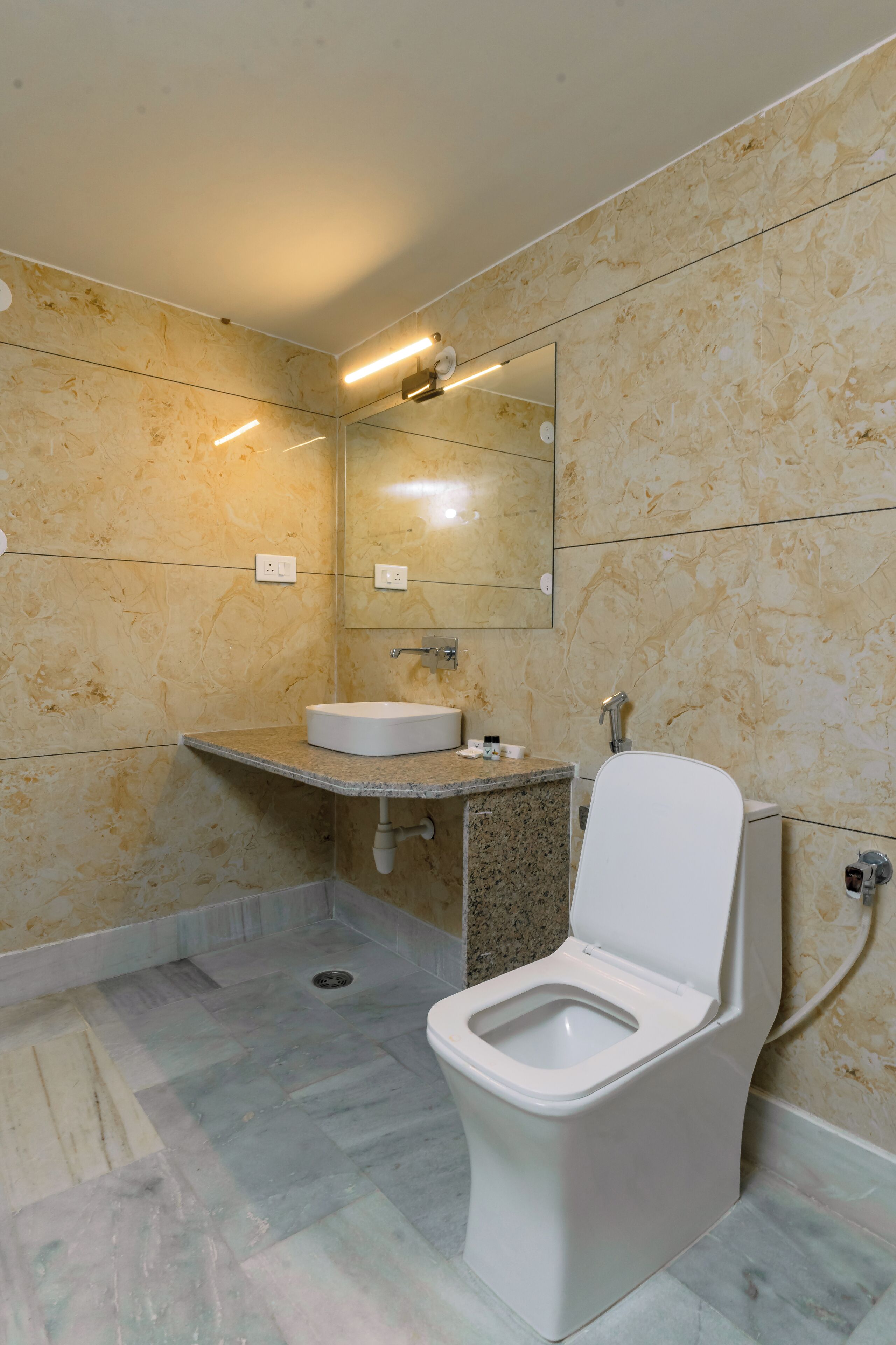 A modern bathroom with a toilet, sink, and mirror.
