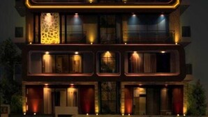 A multi-story building with illuminated balconies and a modern architectural design. - HOTEL MANNAT INTERNATIONAL (Kanthi)