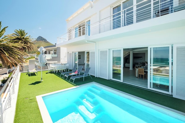 Relax in a serene outdoor setting with a swimming pool and enjoy scenic views from the dining and living areas.