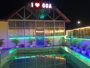 A building with a sign that reads "I ♥ GOA" and a pool area with potted plants and green lighting. - GLEN RESIDENCY  (Cuncolim)