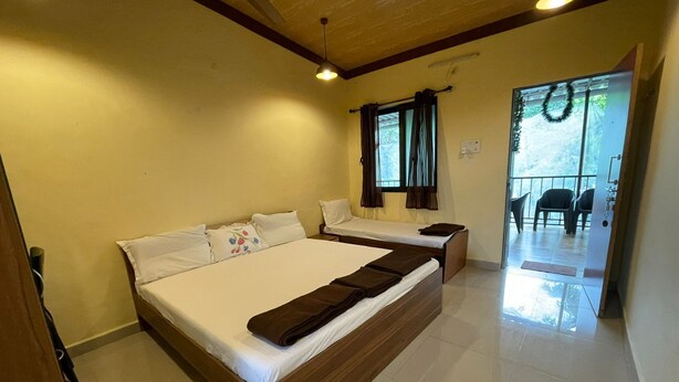 A hotel room with two beds, a balcony, and a view of the outdoors. - RS Farms (Bhiwandi)
