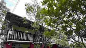 A traditional house with a red exterior, a balcony, and a garden area. - RS Farms (Bhiwandi)