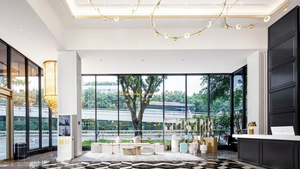 A modern hotel lobby with a check-in counter, seating area, and large windows offering a view of the outdoors. - Pazhou XANA Deluxe International Hotel Pazhou Convention and Exhibition Center Nanzhou Subway Metro Branch - Free Shuttle Bus to Canton Fair Complex During Canton Fair Period (Guangzhou)