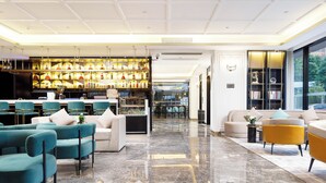 A modern hotel lobby with a bar area, seating arrangements, and a view of the outdoors. - Pazhou XANA Deluxe International Hotel Pazhou Convention and Exhibition Center Nanzhou Subway Metro Branch - Free Shuttle Bus to Canton Fair Complex During Canton Fair Period (Guangzhou)