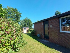 A small brick building with a door and window, surrounded by a grassy area and trees. - Holiday Retreat in Sint Maartenszee (Sint Maartensvlotbrug)